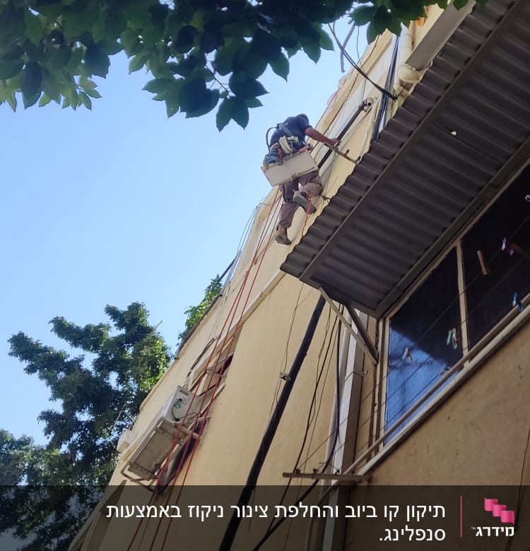 אדם מטפס על קיר עם ציוד עבודה